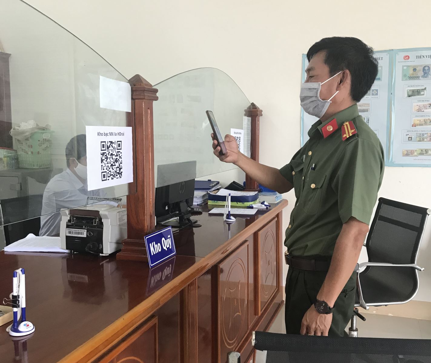 Khách hàng khi đến giao dịch tại Kho bạc nhà nước huyện Ia H'Drai phải quét mã QR Code  qua ứng dụng “bluezone”